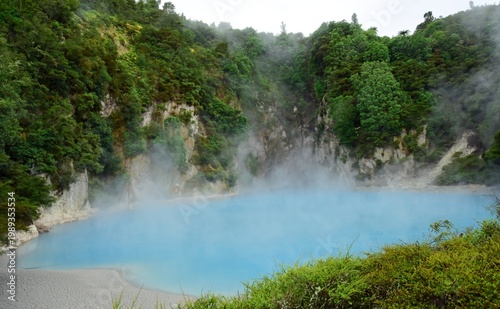 cliffs, steam and the stunningly blue  inferno crater lake in the waimangu volcanic rift valley near rotorua, on the north island of new zealand,  on a summer day