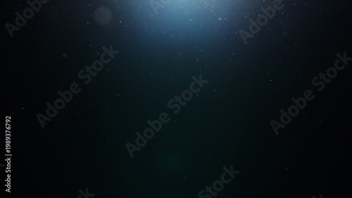 dust particles floating mid air over dark background with some lens flare