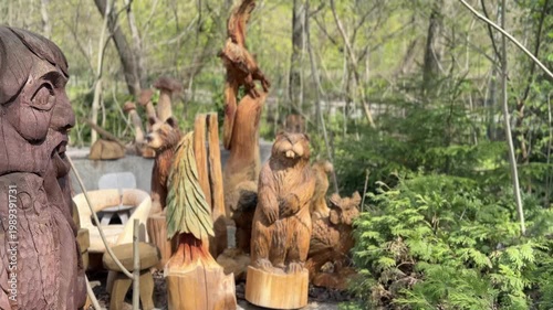 Wooden carved sculptures in forest setting, outdoor art and craftsmanship concept, handmade figures, rustic design, nature environment, decorative scene