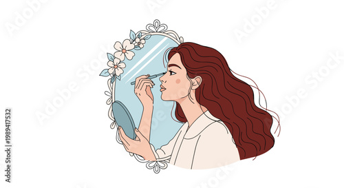 Beautiful young woman with long wavy hair applying eyeliner while looking into a floral decorative mirror at her vanity.