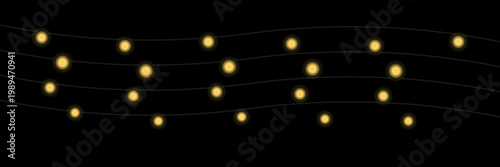 Glowing string lights on black background with thin wires in warm cozy lighting for festive decoration