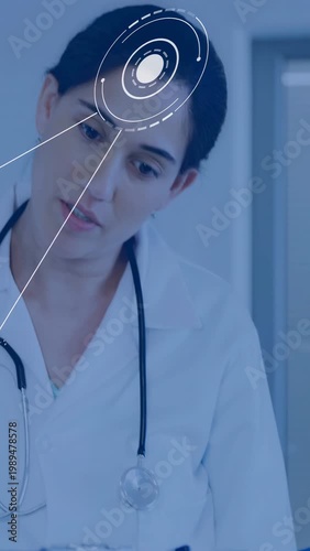 Vertical video: Female doctor reading blue clipboard and activating HUD, tilting head for diagnosis