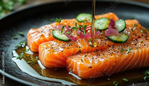 Fresh salmon fillets drizzled with oil, garnished with cucumber, onion, and herbs on a dark plate