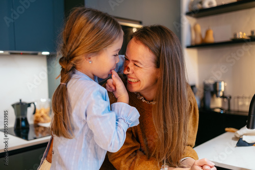 Foto Mother and daughter smiling, having fun together during cooking activities in th