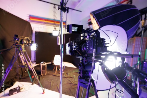 Bright studio lights illuminate a modern podcast space filled with professional cameras and equipment. The atmosphere is energetic as preparations are underway for an engaging interview session