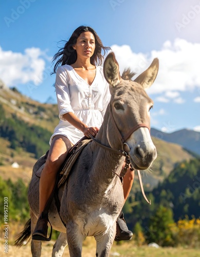 A woman in a white dress rides a donkey in a scenic mountain setting with blue sky and sunlight