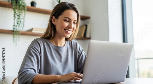 Happy young woman working on laptop at home office