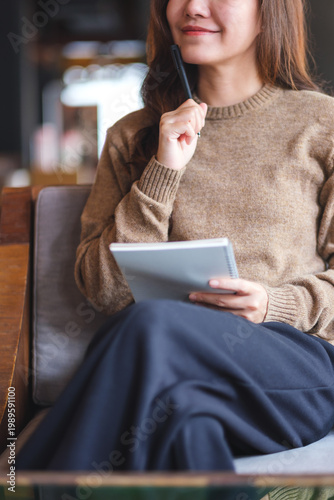 Принти на полотні Vertical closeup image of a woman thinking and writing on a notebook