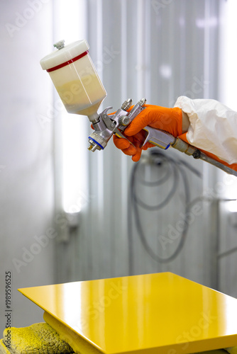 Fotografía Spray Gun and Yellow Painted Panel Close Up Industrial Coating Result