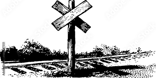Railroad crossbuck sign standing beside tracks in field