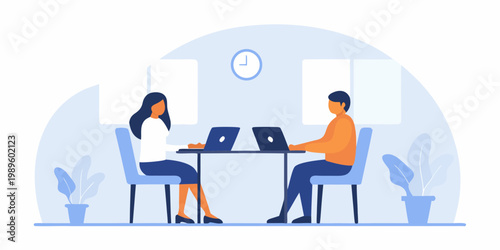 Two people collaborating on laptops at a shared workspace indoors