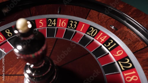 Hand spinning roulette wheel with ball in casino, close up