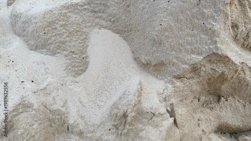 Natural sand texture with subtle wave patterns and soft cream color gradations, suitable as a minimalist background or nature-themed design element.