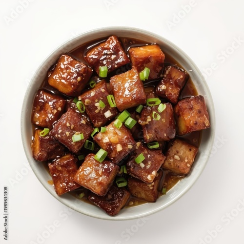Crispy slow-roasted pork belly cubes with a honey-soy glaze and a garnish of sliced green onions. Generative AI