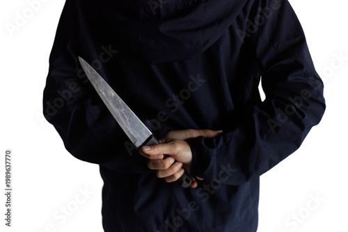 The Hidden Threat: Person in Dark Hoodie Concealing a Large Knife Behind Back