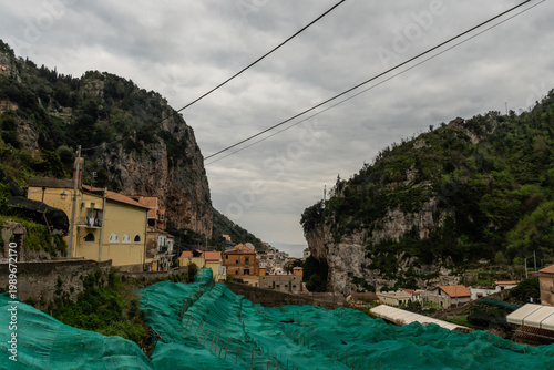 Sfusato lemon grove covered by protective netting in a mountainous valley on a heavily overcast day, Amalfi, Amalfi Coast, Southern Italy