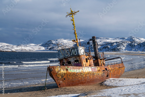 Photos The old fishing trawler on the shore of Lodeynaya Guba Bay on a March day
