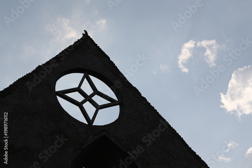 Vászonkép Silhouette of a bird perched on the apex of a ruined building with a star-shaped