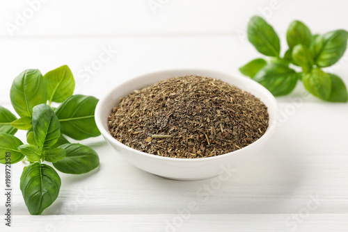 Принти на полотні Dry basil in bowl and fresh leaves on white wooden table, closeup
