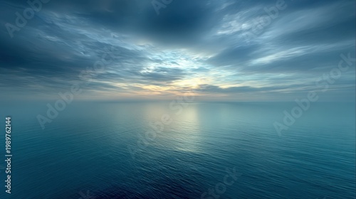 Serene Ocean Horizon Under Dramatic Cloudy Sky at Dawn with Soft Blue Tones and Gentle Reflections on Water Surface
