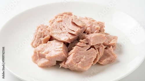 Canned tuna chunks on white plate, cooked tuna meat pieces, simple protein seafood food for meal prep isolated PNG with Transparent Background