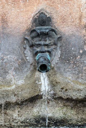 Fountain with spout with the facs of elves in Siguenza, province of Guadalajara. Spain