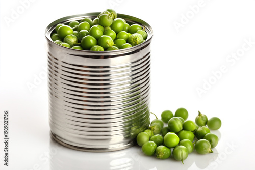 A shiny, corrugated tin can overflowing with bright green peas on white background.