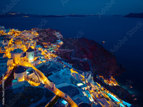 Aerial view of Oia town and caldera on Santorini island ay night, Greece. 