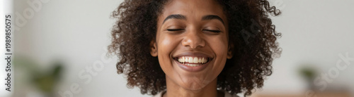 shot african american woman face shows smiling widely eyes closed set soft focus blur warm