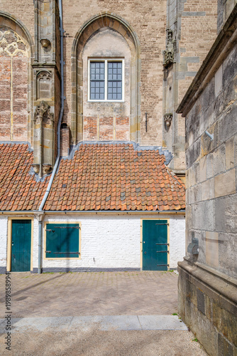 White painted building with blue door near brick church