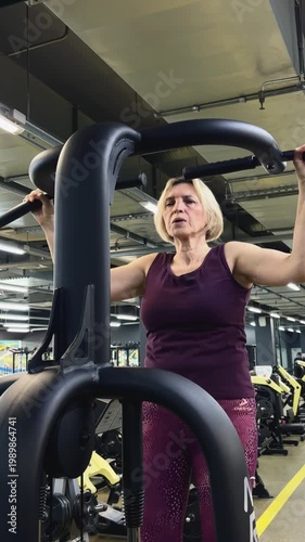 Russia, Izhevsk, April 16, 2026, fitness center. Mature woman exercising on fitness machine in gym environment  