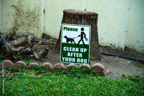 Please clean up after your dog sign posted near a tree stump