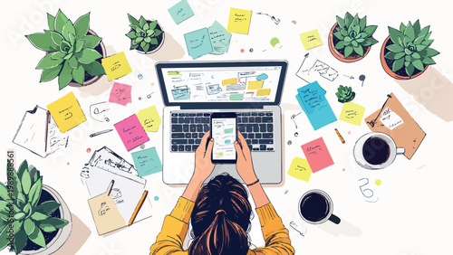 Person busy working on cluttered desk with laptop and phone