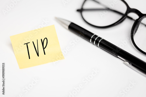 A black pen, dark-bound glasses, and a yellow self-adhesive card with the inscription 