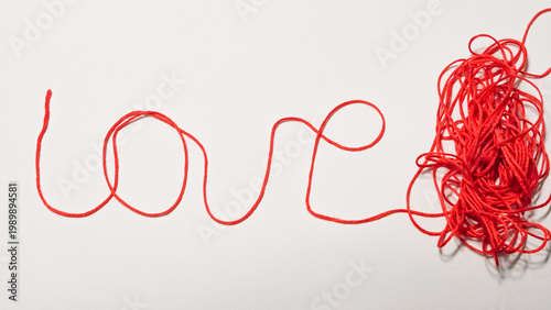 Canvastavla Red string forming the word love with tangled yarn on white background