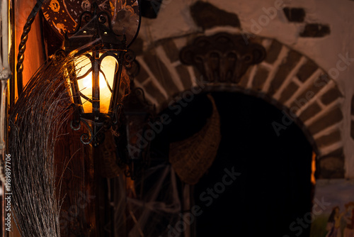 Spooky Halloween lantern and broomstick decoration casting warm light at dusk