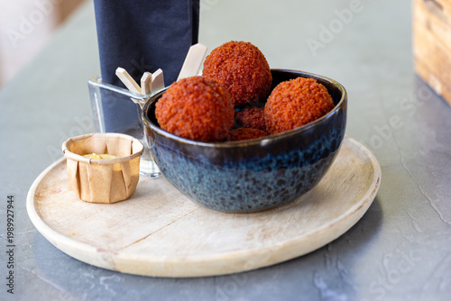 Crispy Dutch Bitterballen with Mustard Sauce on Wooden Board - Traditional Snack Close-Up