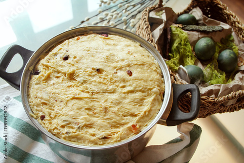Raw dough with raisins in the metal bowl