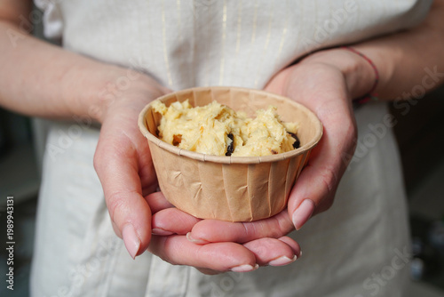 Holding a kulich mold with raw dough