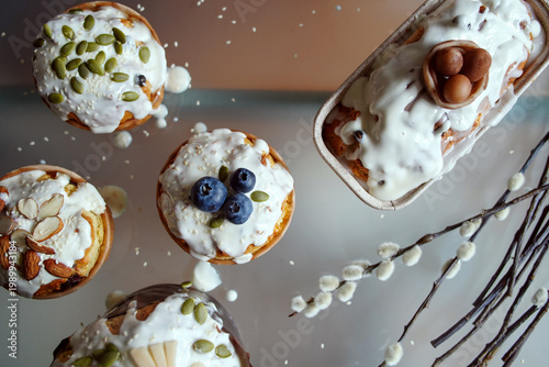 Easter cakes decorated with cream, berries, and seed decoration, pussy willow twigs