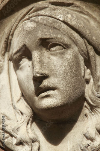 Fotografija Close up of sorrowful Virgin Mary statue looking upward, symbol of grief, faith