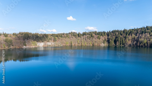 Fotografi Vue panoramique du Lac Pavin, maar volcanique entouré de forêt en Auvergne