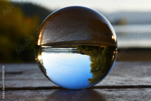 An image of a photography lens ball showing the inverted image of a sandy beach with calm lake waters in British Columbia, Canada. 