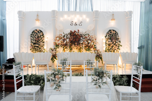 Elegant White Wedding Stage Decoration with Floral Arches and Classic Scalloped Seating
