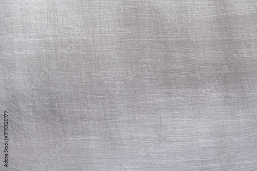 Close-up of brushed aluminum texture background with light reflection, industrial metallic surface.