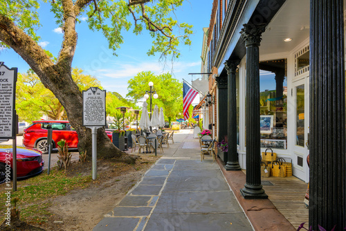 Foto American flags and historical markers outside of sidewalk cafes and shops along picturesque Front Street, the main street through the historic early American town of Georgetown, South Carolina