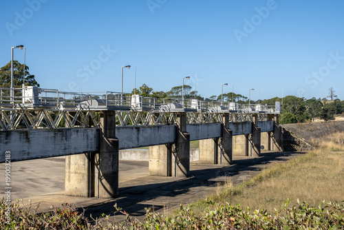 Canvas Print Malmsbury Reservoir water control weir in regional Victoria, Australia featuring multiple concrete piers, steel sluice gates, gantry frames, during drought conditions with a dry empty spillway