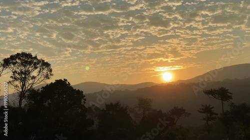 Golden sunrise lights up the Western Ghats of India, painting misty peaks, green valleys, and drifting clouds in a breathtaking moment of pure morning serenity.
