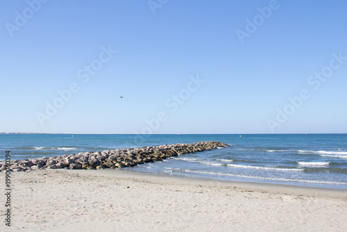 Le Boucanet beach in Le Grau-du-Roi with rocky breakwater, France