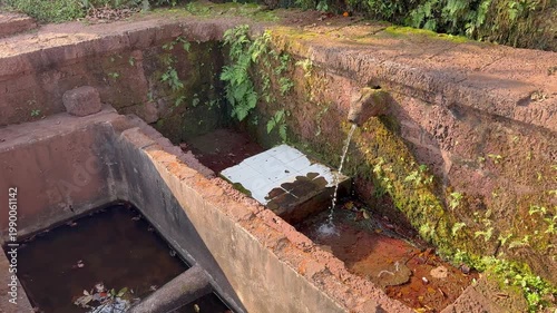Beautiful 4K view of the sacred Gaumukh at Karhateshwar Temple, Ratnagiri Konkan, where crystal-clear water flows through ancient stone carvings amid serene coastal greenery and divine peace.